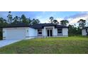 Beautiful single-story home featuring a two-car garage and well-maintained lawn at 23490 Macbeth Ct, Punta Gorda, FL 33980