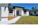 A charming single-story home with a well-manicured lawn, gray roof, and a welcoming front entrance at 23490 Macbeth Ct, Punta Gorda, FL 33980