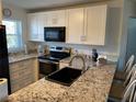 Bright kitchen features granite counters, stainless steel appliances, and sleek black hardware at 25100 Sandhill Blvd # I201, Punta Gorda, FL 33983