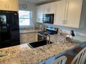Bright kitchen features granite counters, stainless steel appliances, and sleek black hardware at 25100 Sandhill Blvd # I201, Punta Gorda, FL 33983