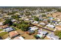 Aerial view of a residential neighborhood showcasing a home with a screened-in pool and lush greenery at 2550 Ivanhoe St, Port Charlotte, FL 33952