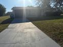Single story home with a well-maintained front yard and driveway at 3209 Sunrise Trl, Port Charlotte, FL 33952