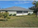 The backyard features a lush green lawn with mature landscaping providing privacy and a serene outdoor space at 501 San Cristobal Ave, Punta Gorda, FL 33983