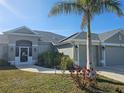 Charming home featuring a well-manicured lawn, a palm tree, and a welcoming entrance at 501 San Cristobal Ave, Punta Gorda, FL 33983