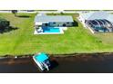 Stunning aerial view of a waterfront property featuring a private pool and lush green lawn at 61 Caddy Rd, Rotonda West, FL 33947