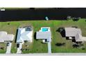 Overhead aerial view of real estate showcasing well-maintained properties, landscaping, and waterfront access at 61 Caddy Rd, Rotonda West, FL 33947