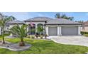 Beautiful home featuring lush lawn, landscaped flower beds, and a two-car garage at 664 Rotonda Cir, Rotonda West, FL 33947