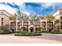 Up close outdoor shot of a condominium building with a beautiful entrance and mature landscaping at 87 Vivante Blvd # 8732, Punta Gorda, FL 33950