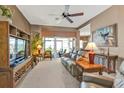 Spacious living room with ceiling fan and views of the outdoor lanai at 12905 N Marsh Dr, Port Charlotte, FL 33953