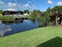 The serene backyard pond has a private dock and beautiful view of the screened pool area at 13902 Allamanda Cir, Port Charlotte, FL 33981