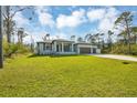 Attractive one-story home featuring a well-maintained front lawn and appealing blue exterior at 14325 Mcfarland Ave, Port Charlotte, FL 33981