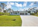 Beautiful single-story home with three-car garage, well-manicured lawn and blue-painted exterior at 14325 Mcfarland Ave, Port Charlotte, FL 33981
