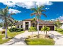 Stunning single-story home with a manicured lawn, stone driveway, and multiple palm trees enhancing its curb appeal at 197 Colony Point Dr, Punta Gorda, FL 33950