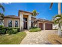 Attractive single-story home featuring a well-kept lawn, mature landscaping, and a spacious driveway leading to the garage at 197 Colony Point Dr, Punta Gorda, FL 33950