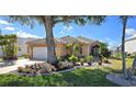 Charming single-story home with lush landscaping, mature tree, and a neutral exterior paint at 26287 Stillwater Cir, Punta Gorda, FL 33955