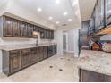 Spacious kitchen with dark cabinetry, granite countertops, stainless steel appliances and travertine tile floor at 31093 N Bend St, Punta Gorda, FL 33982