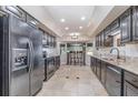 A kitchen featuring dark wood cabinetry, granite countertops, stainless steel appliances, and a breakfast bar with seating at 31093 N Bend St, Punta Gorda, FL 33982