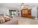 Cozy living room with a large sectional couch, tiled floors, ceiling fan, and sliding glass doors to the patio at 31093 N Bend St, Punta Gorda, FL 33982