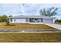 Charming single-story home with a well-maintained lawn, purple paint, and a cozy screened porch at 3940 Abbotsford St, North Port, FL 34287