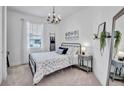 Cozy bedroom with a metal bed frame, neutral decor, and a sunlit window at 42210 Lake Timber Dr, Punta Gorda, FL 33982