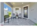 Inviting front porch with rocking chairs and a bench, perfect for enjoying the outdoors at 42210 Lake Timber Dr, Punta Gorda, FL 33982