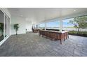 Spacious outdoor lanai with a comfortable seating area, stone pavers, and scenic lake views at 42239 Lake Timber Dr, Punta Gorda, FL 33982