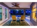 Relaxing screened-in lanai with seating overlooking a pool illuminated by blue lights at night at 4529 Enid Ln, North Port, FL 34288