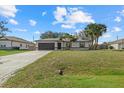 Well-kept single-story home with a brick driveway and a lush green lawn at 5113 Weatherton St, North Port, FL 34288