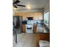 Well-lit kitchen with updated stainless steel appliances, granite countertops, and wood cabinets at 5240 Malamin Rd, North Port, FL 34287