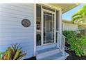 Close-up of the home's entrance featuring a stylish front door, address number, and decorative plants at 621 Trabue Ave, Punta Gorda, FL 33950
