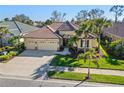 Aerial view of a home with tile roofing, three-car garage, and manicured lawn in a desirable neighborhood at 1321 Eagles Flight Way, North Port, FL 34287