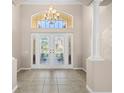 Spacious foyer features decorative glass doors, tile flooring, and a large arched transom window at 1321 Eagles Flight Way, North Port, FL 34287