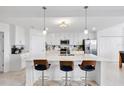 Kitchen island with seating, stainless appliances, and white cabinets at 15970 Grassland Ln # 2816, Punta Gorda, FL 33982