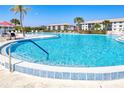 The community pool is surrounded by lounge chairs and palm trees at 175 Kings Hwy # 232, Punta Gorda, FL 33983