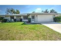 Charming single-story home featuring a well-manicured lawn and an attached two-car garage at 21229 Giddings Ave, Port Charlotte, FL 33952