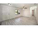 Bright, open living room featuring new flooring, a ceiling fan, and a front entry door at 21229 Giddings Ave, Port Charlotte, FL 33952