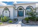 A stunning entrance with a blue double door, decorative stone pathway and lush landscaping at 2181 Via Seville, Punta Gorda, FL 33950