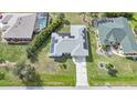 Aerial view of a house featuring solar panels, screened-in pools, and a well-maintained landscape at 25069 Bolivar Dr, Punta Gorda, FL 33983