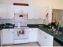 Well-lit kitchen featuring white cabinets, updated countertops, and modern appliances at 5098 Adina Cir, North Port, FL 34291