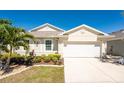 Charming single-story home with a well-manicured lawn and a two-car garage, complemented by a lush palm tree at 7304 W Lenox Circle, Punta Gorda, FL 33950