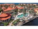 Beautiful aerial view of resort style pool, clubhouse and tropical landscape at 99 Vivante Blvd # 404, Punta Gorda, FL 33950