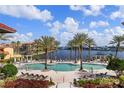 Stunning waterfront community pool with lounge chairs and tropical landscaping at 99 Vivante Blvd # 404, Punta Gorda, FL 33950