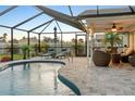 Relaxing screened-in pool and patio area with comfortable seating and lush landscaping at 12107 Gulfstream Blvd, Port Charlotte, FL 33981