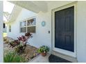 Home featuring a blue door, decorative flower pot, and tasteful landscaping with rocks at 14195 Brisk Ave, Port Charlotte, FL 33953