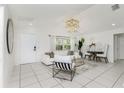 Well-lit living room featuring white furniture, a modern light fixture, and tile floors at 14195 Brisk Ave, Port Charlotte, FL 33953