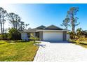 Charming single-story home featuring a gray exterior with stone accents, well-manicured lawn, and a paved driveway at 160 Green Pine Park, Rotonda West, FL 33947