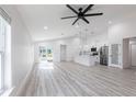 Open-concept living area showcasing light laminate flooring, a modern ceiling fan, and a seamless transition to the adjacent kitchen at 160 Green Pine Park, Rotonda West, FL 33947