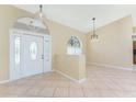 Inviting entryway featuring a decorative front door with sidelights and transom window plus neutral tile flooring at 16571 Cape Horn Blvd, Punta Gorda, FL 33955