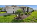 Well-maintained front exterior with a two-car garage, manicured landscaping, and a charming front porch at 17954 Saddle Rd, Punta Gorda, FL 33982