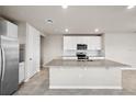 Modern kitchen featuring stainless steel appliances, granite countertops, a large island, and white cabinets at 17954 Saddle Rd, Punta Gorda, FL 33982
